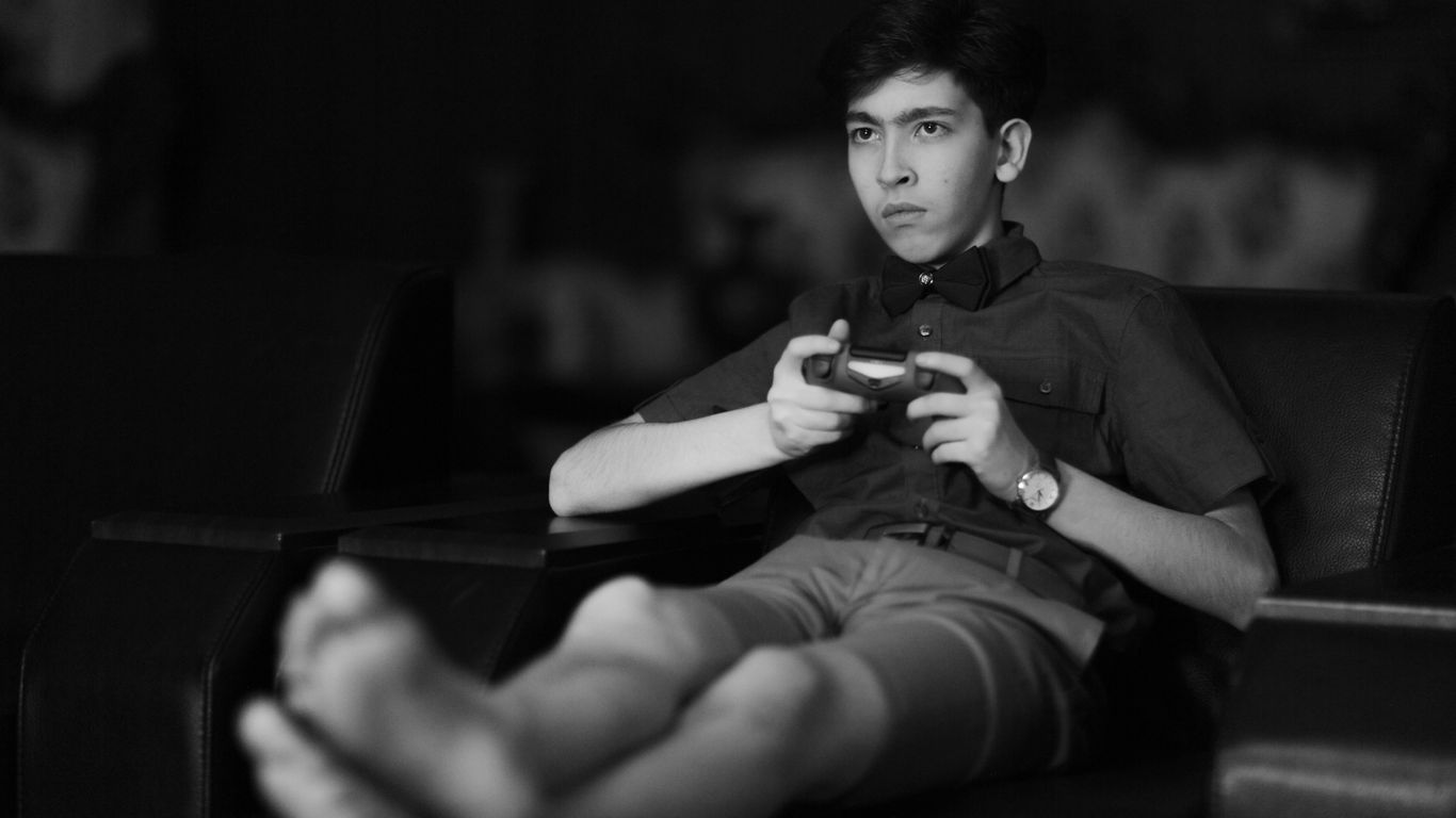 man in black button up shirt and black shorts sitting on chair