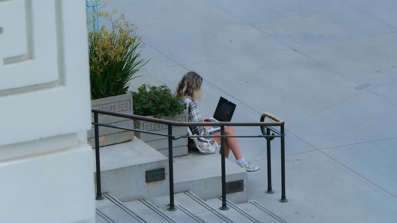 Woman working on laptop on outdoor steps
