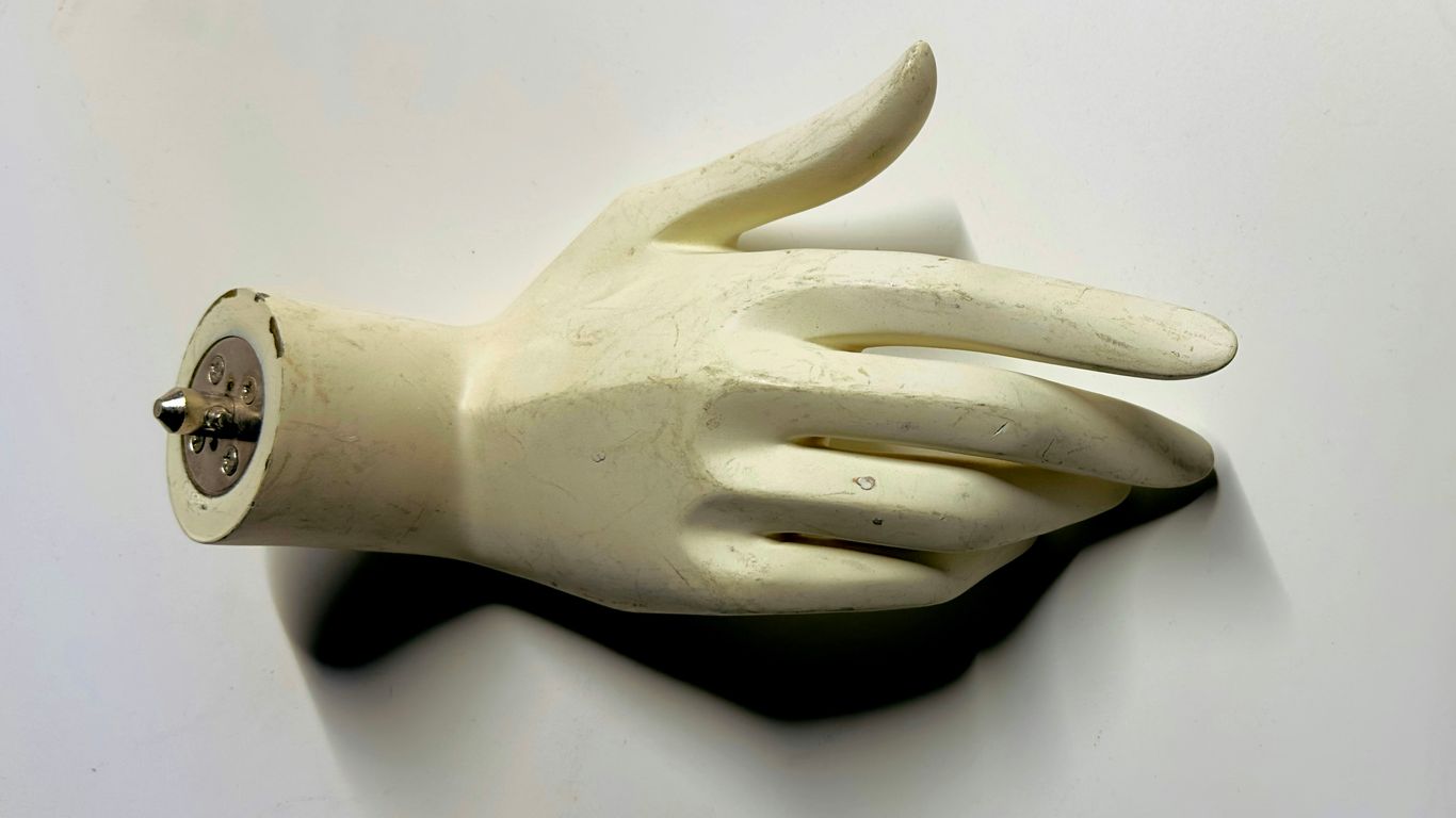 A white glove with a button on it