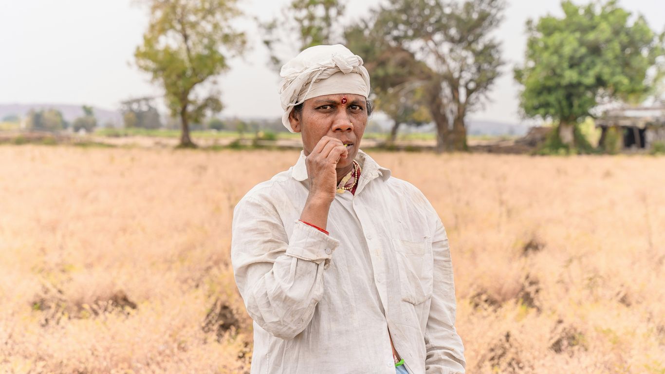 a man standing in a field holding a book