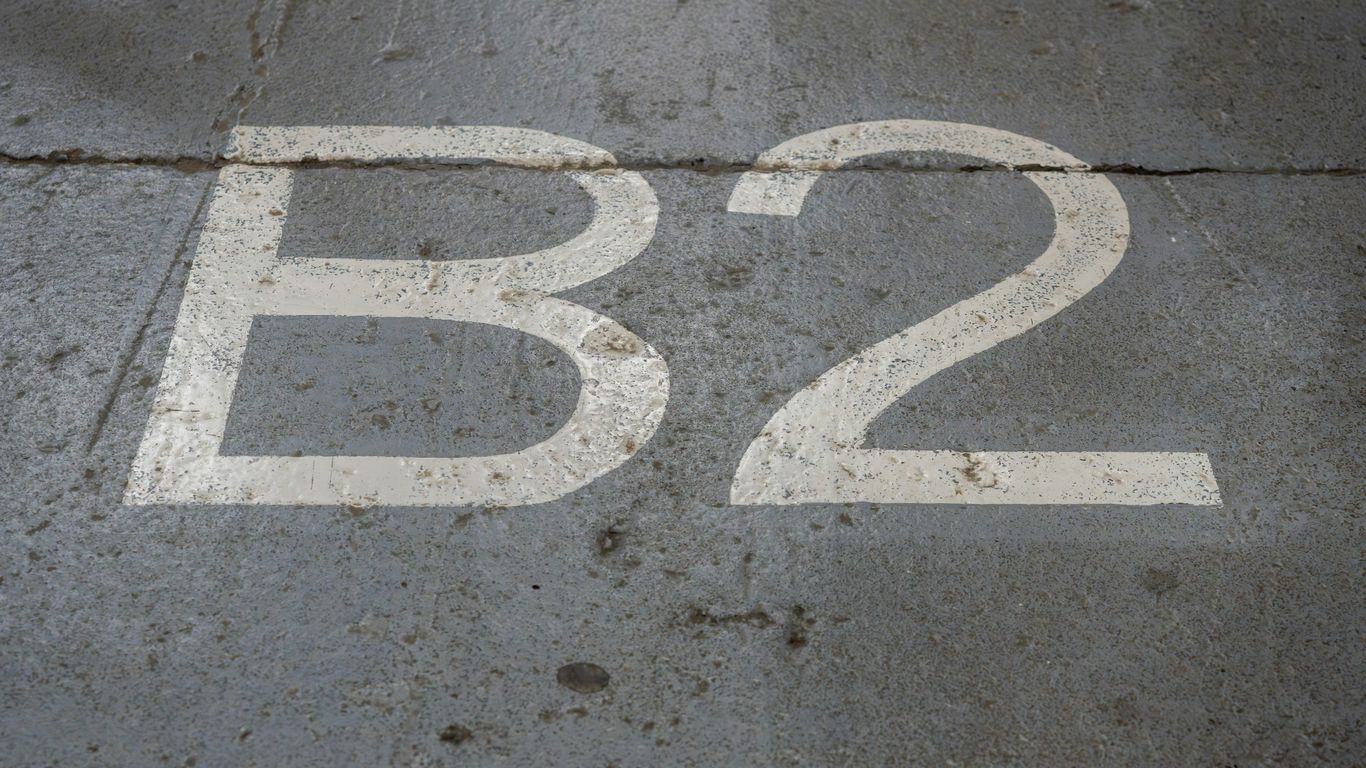 A white b2 sign sitting on top of a sidewalk