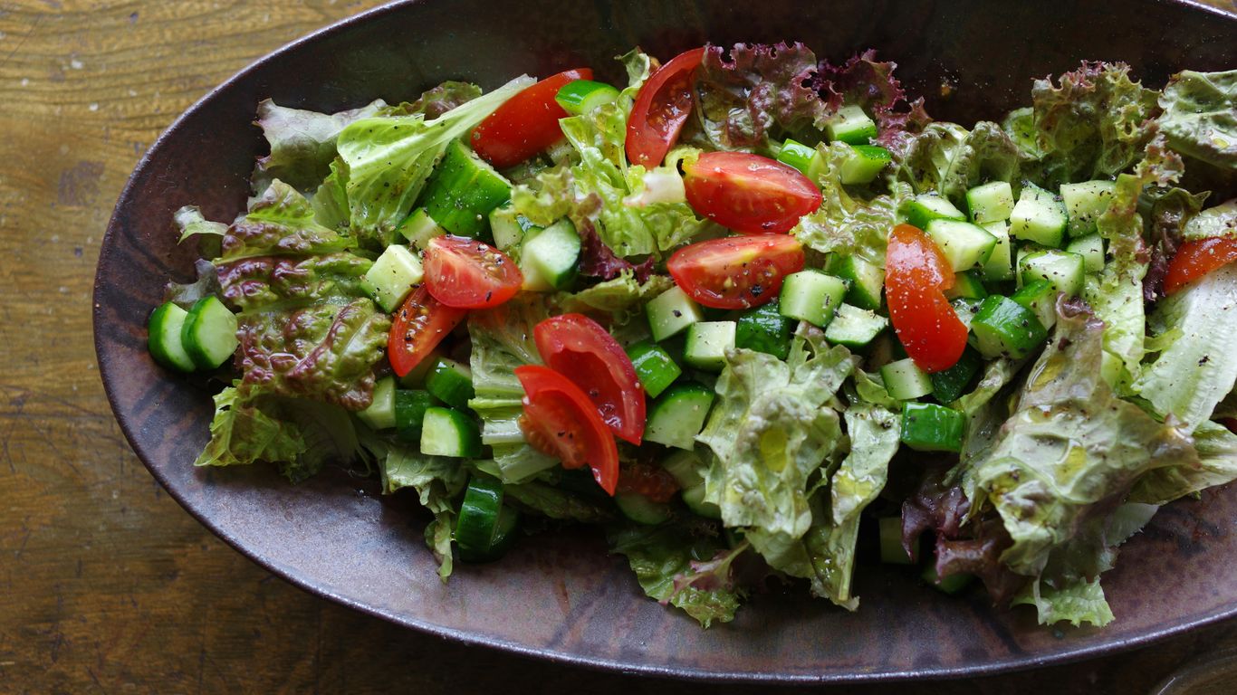 A bowl of salad on a wooden table