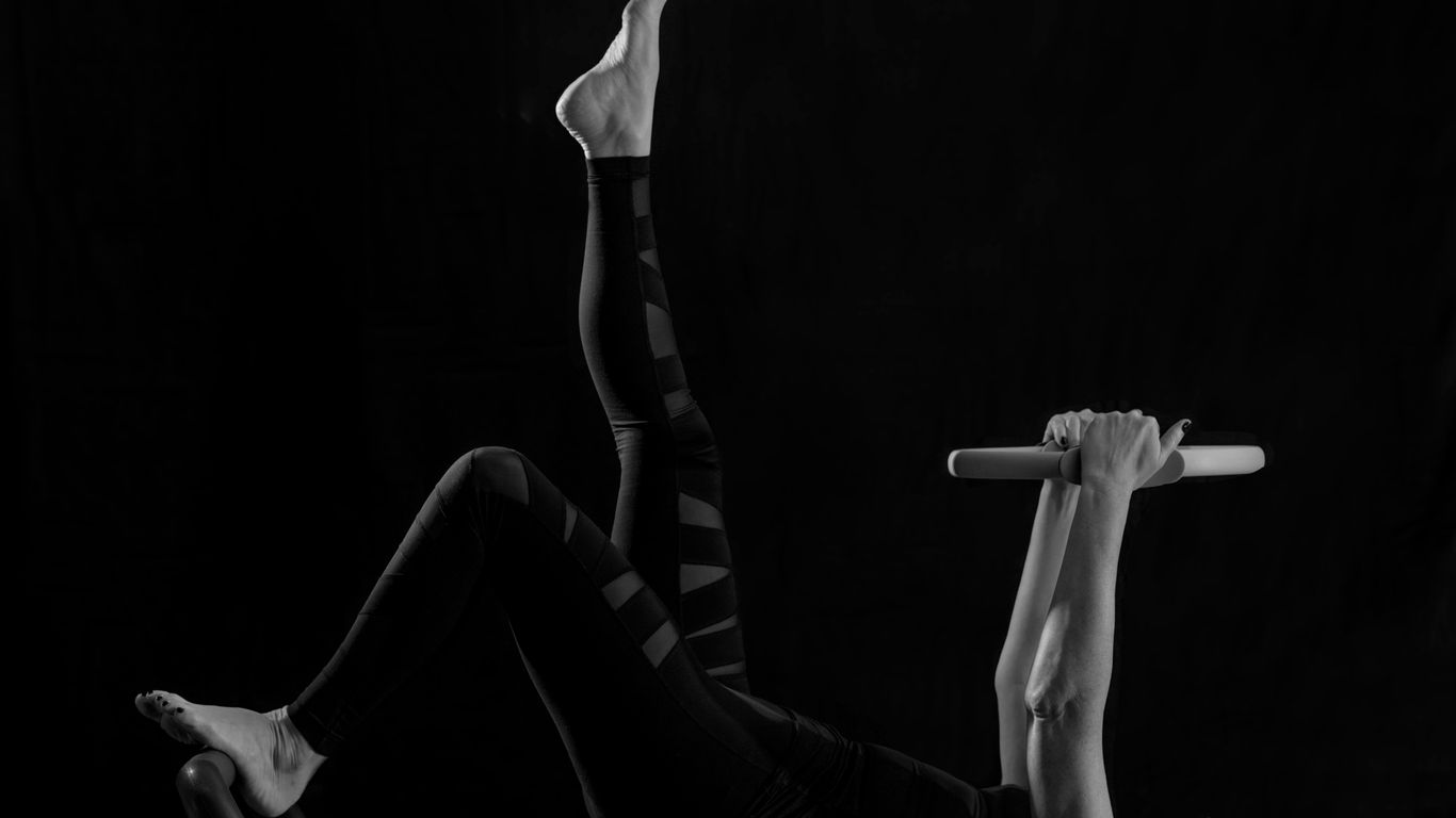 woman in black pants and black boots lying on black wooden bench