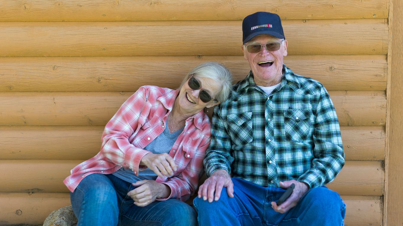 Elderly couple sitting together outdoors
