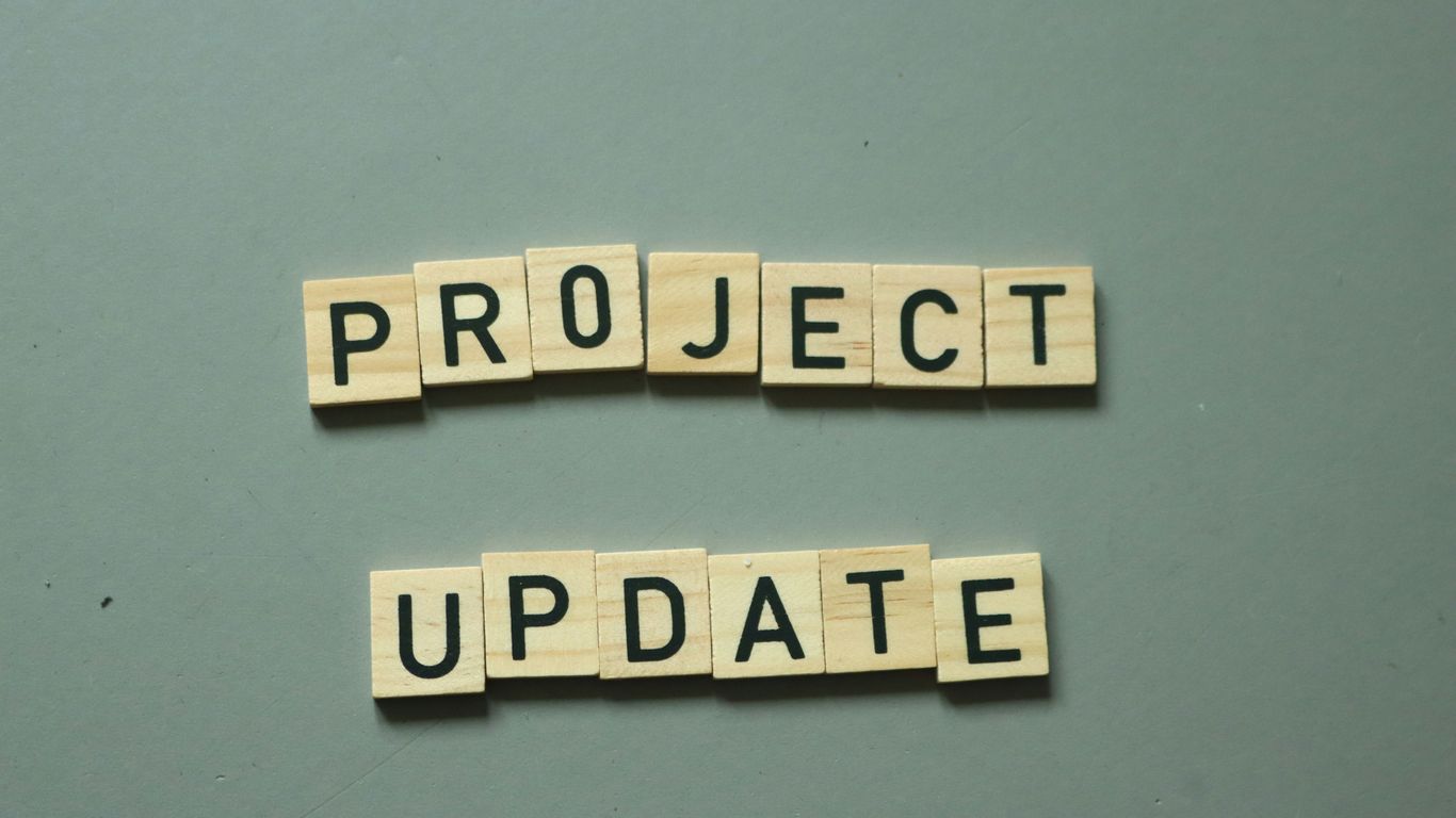 two scrabble tiles spelling project update on a table