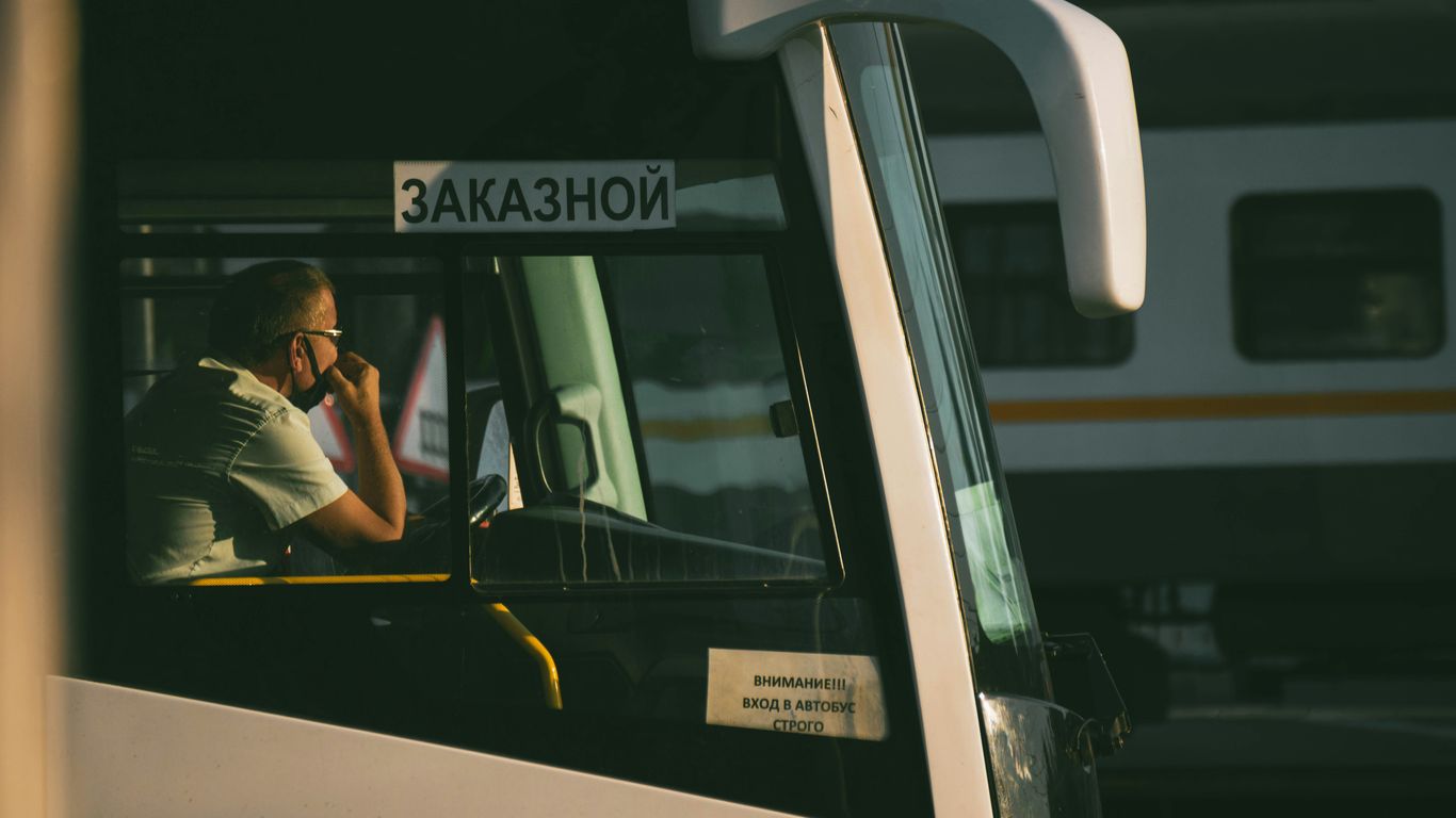 man in black t-shirt sitting on white bus