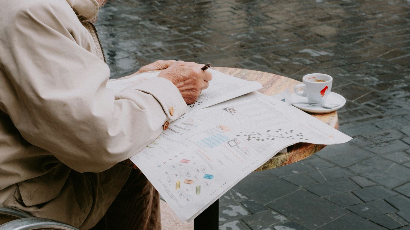 a man sitting at a table writing on a piece of paper