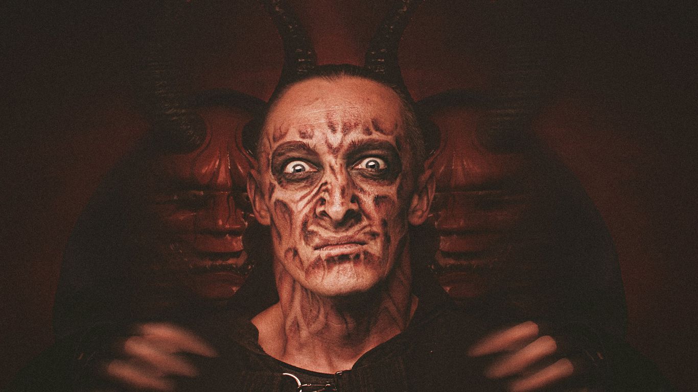 a man with a devilish face and horns on his head