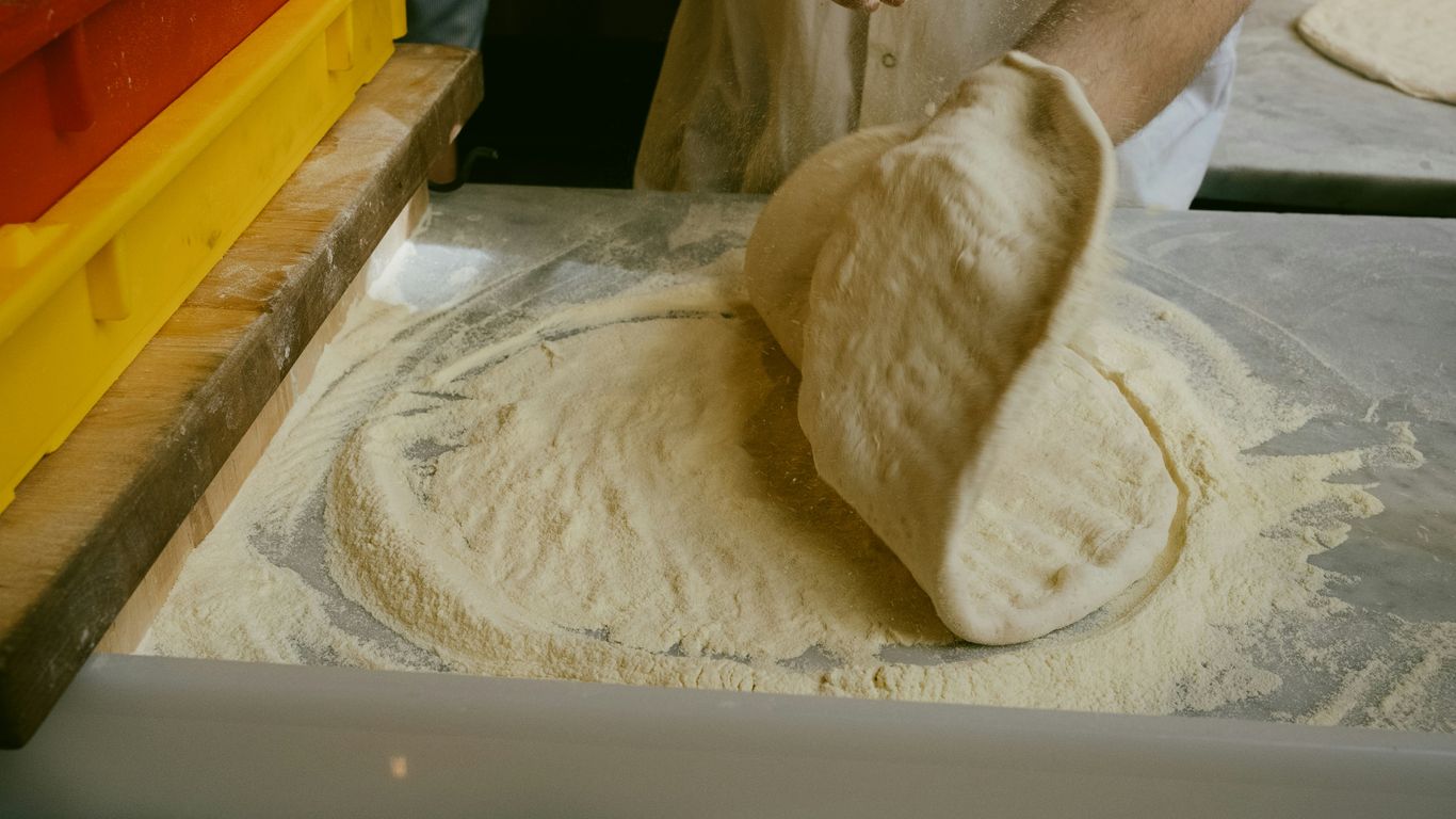 A person in a kitchen preparing food on a counter