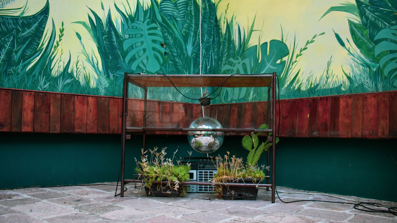 a metal structure with plants and a globe on it