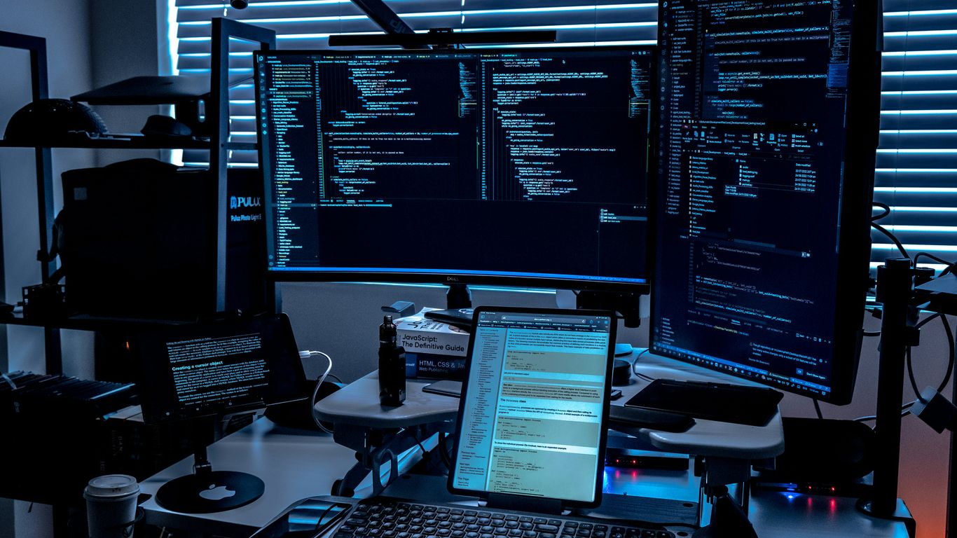 a desk with several monitors