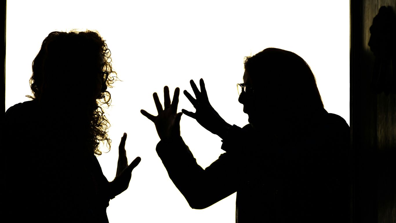 Silhouetted figures engage in a heated argument.