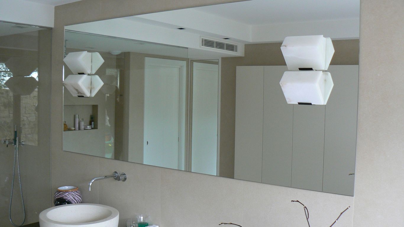 A bathroom with a large mirror and a sink
