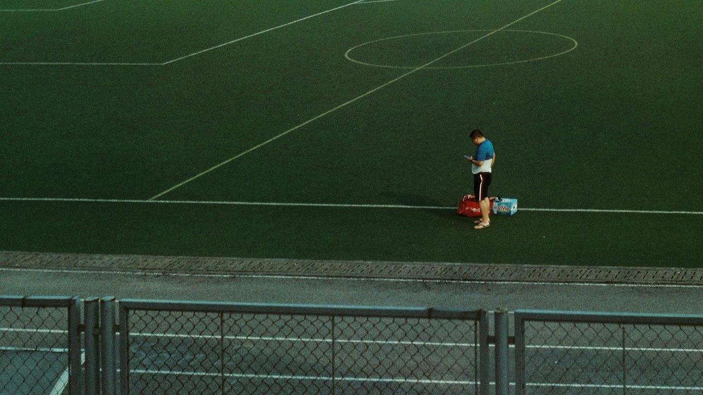 a person standing on a field with a bag
