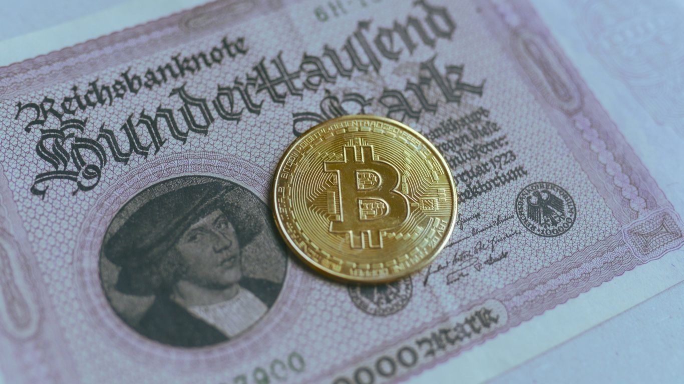 Bitcoin coin on top of a vintage currency note.