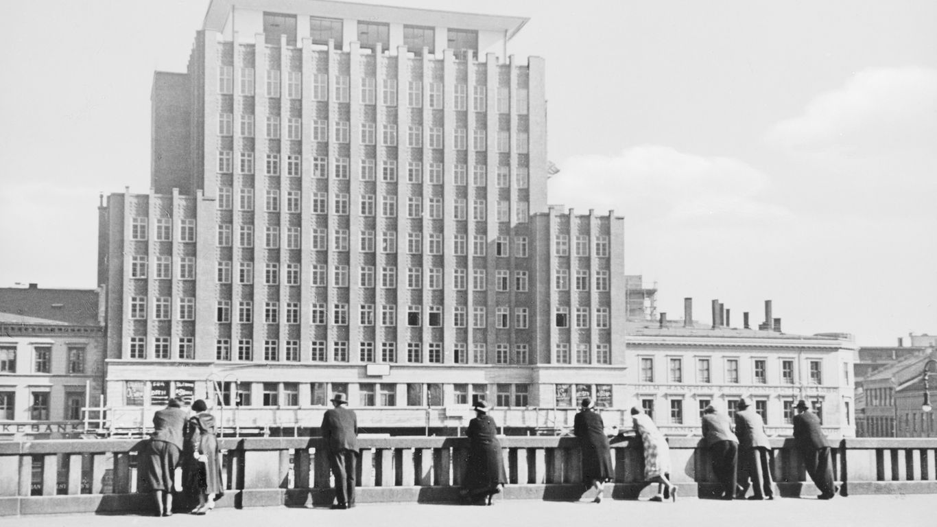 a black and white photo of a group of people standing in front of a building