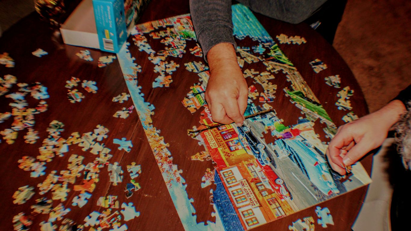a person putting together a puzzle on a table