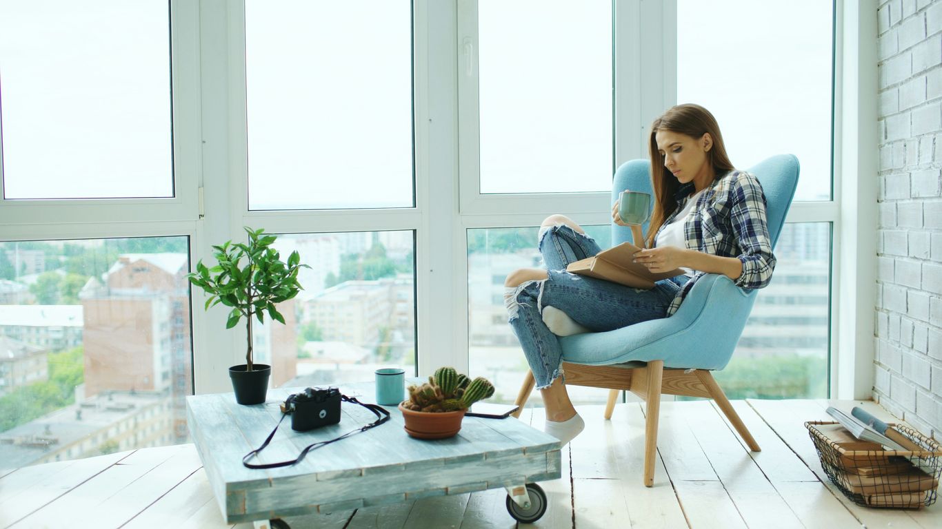 Woman reading a book in a modern armchair.