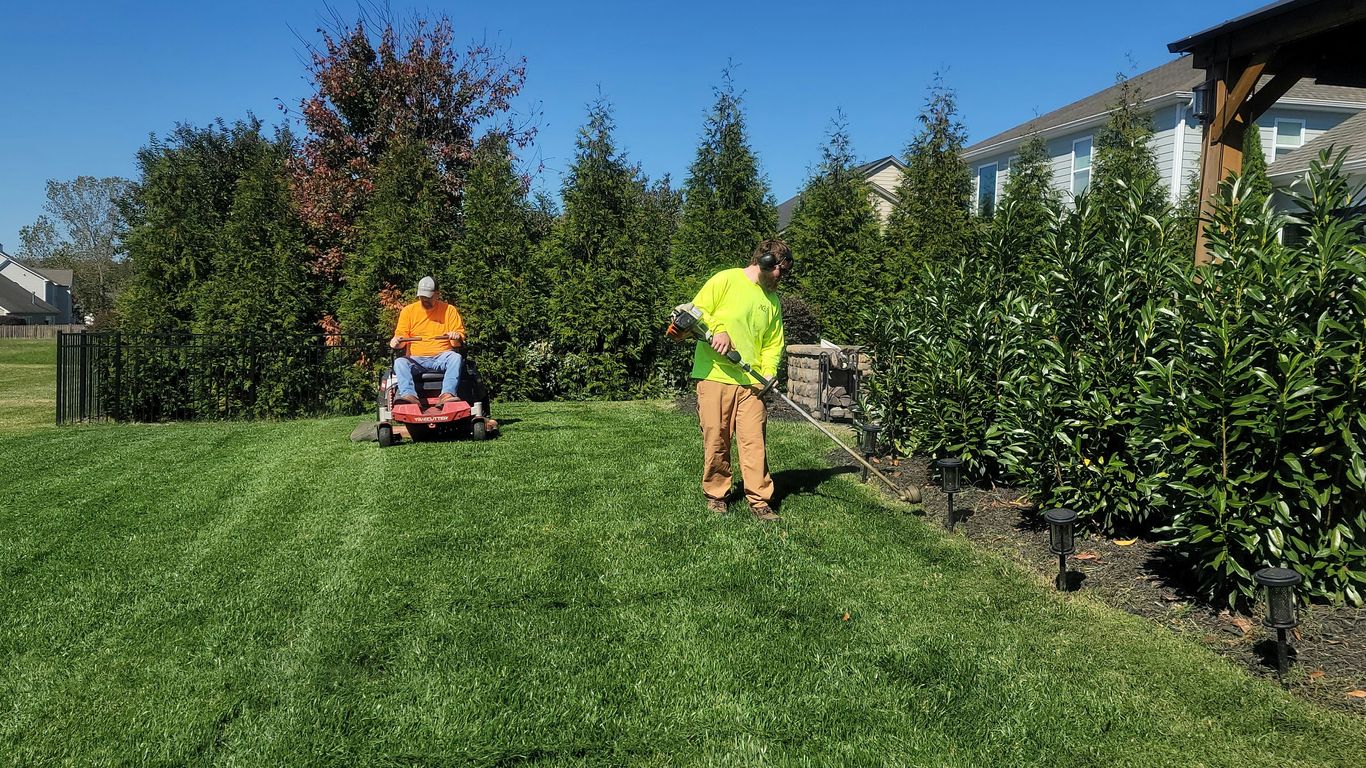 A man mowing a lawn with a lawn mower