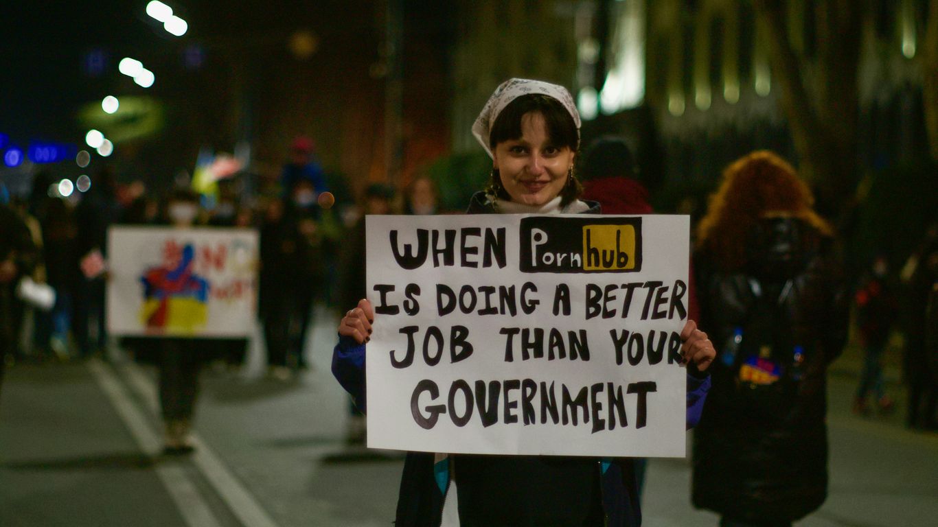 a woman holding a sign that says when it's doing a better job than