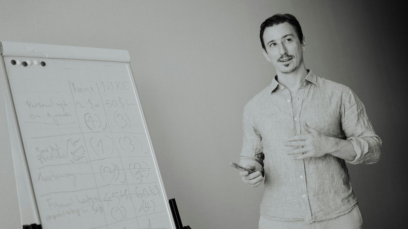 Man presenting at a whiteboard in a meeting.
