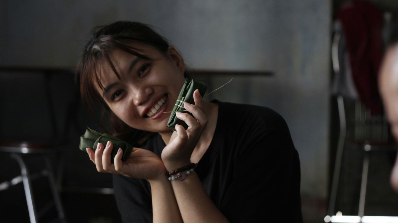 Smiling woman shows off delicious-looking food.