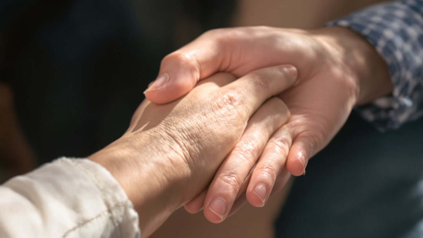 Hands clasped together in a supportive gesture.