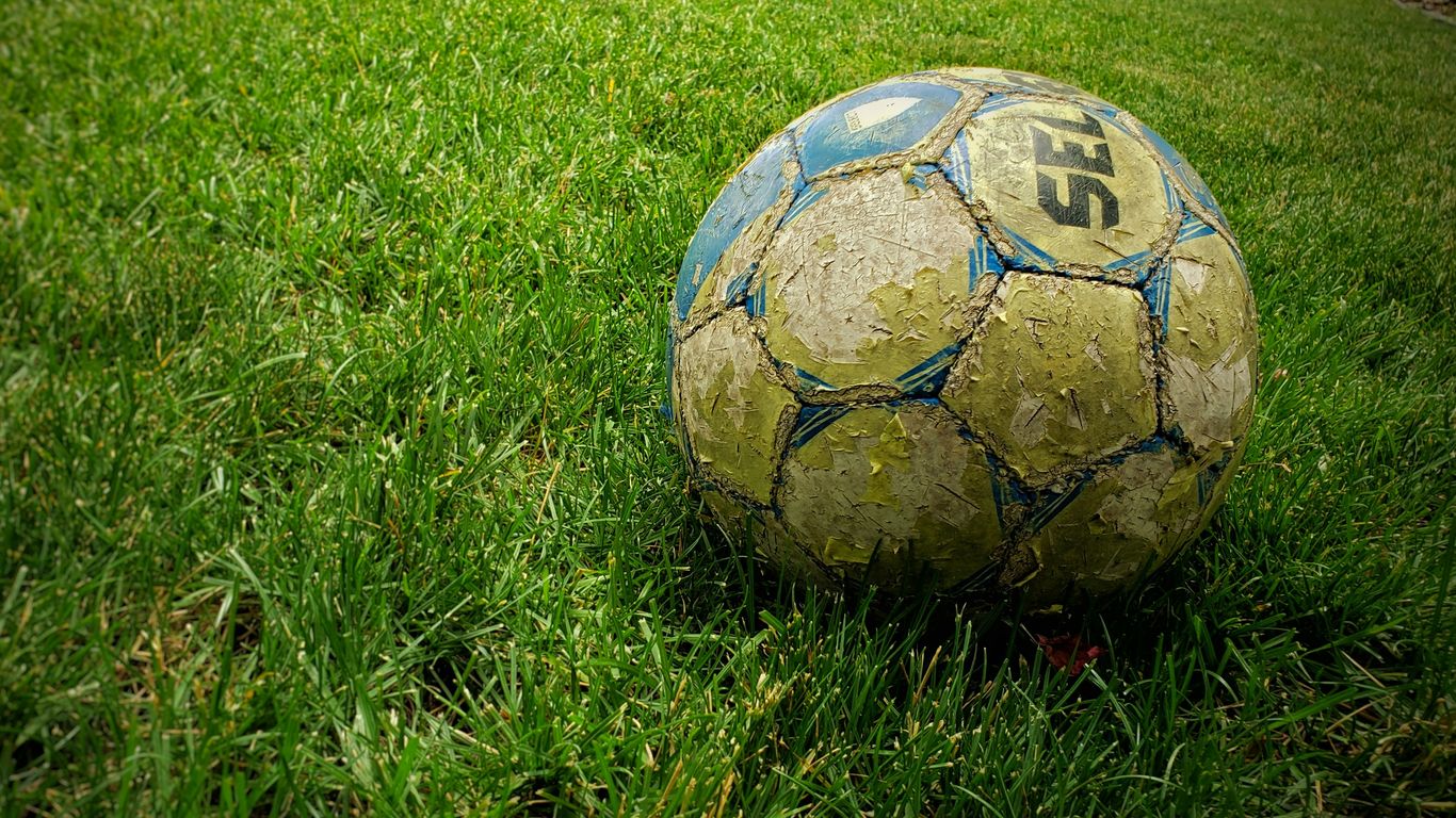 white and blue soccer ball on green grass field
