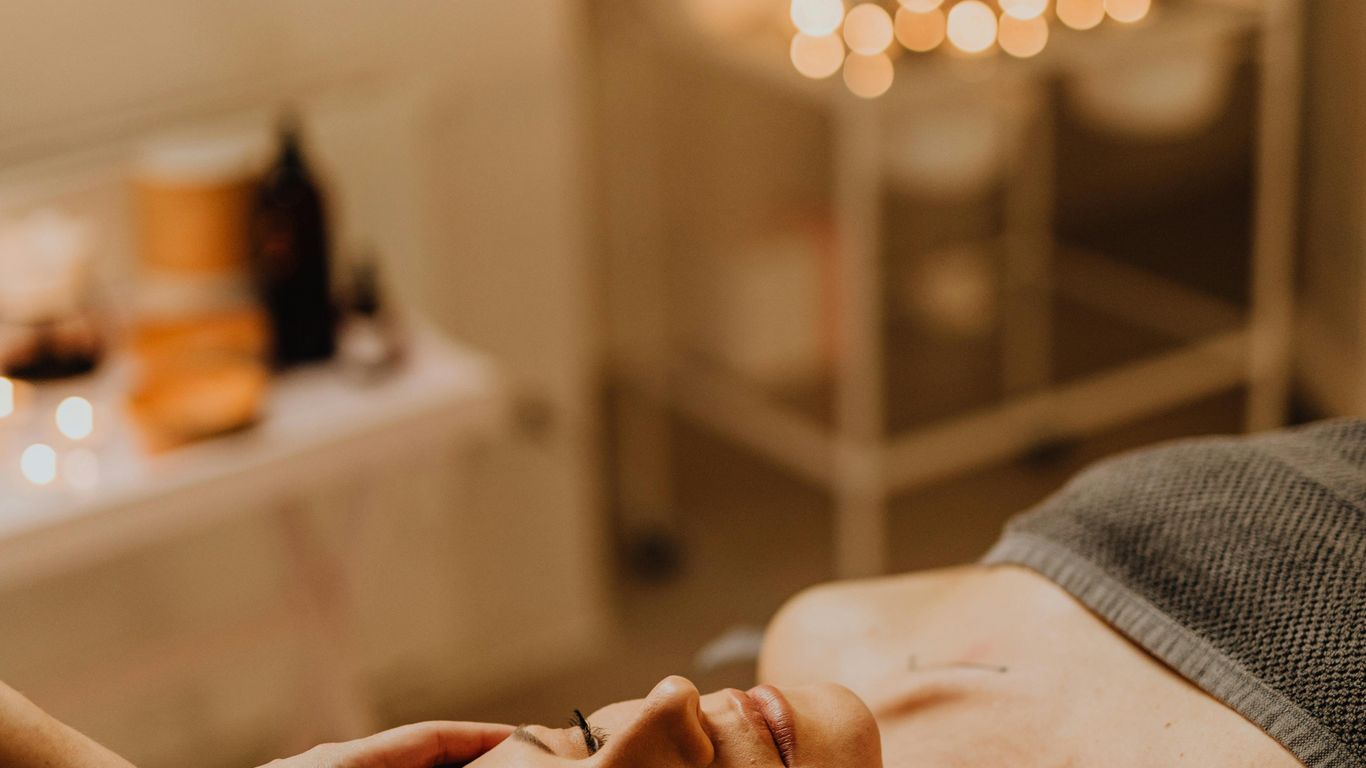 Person receiving a relaxing head massage in a spa setting.
