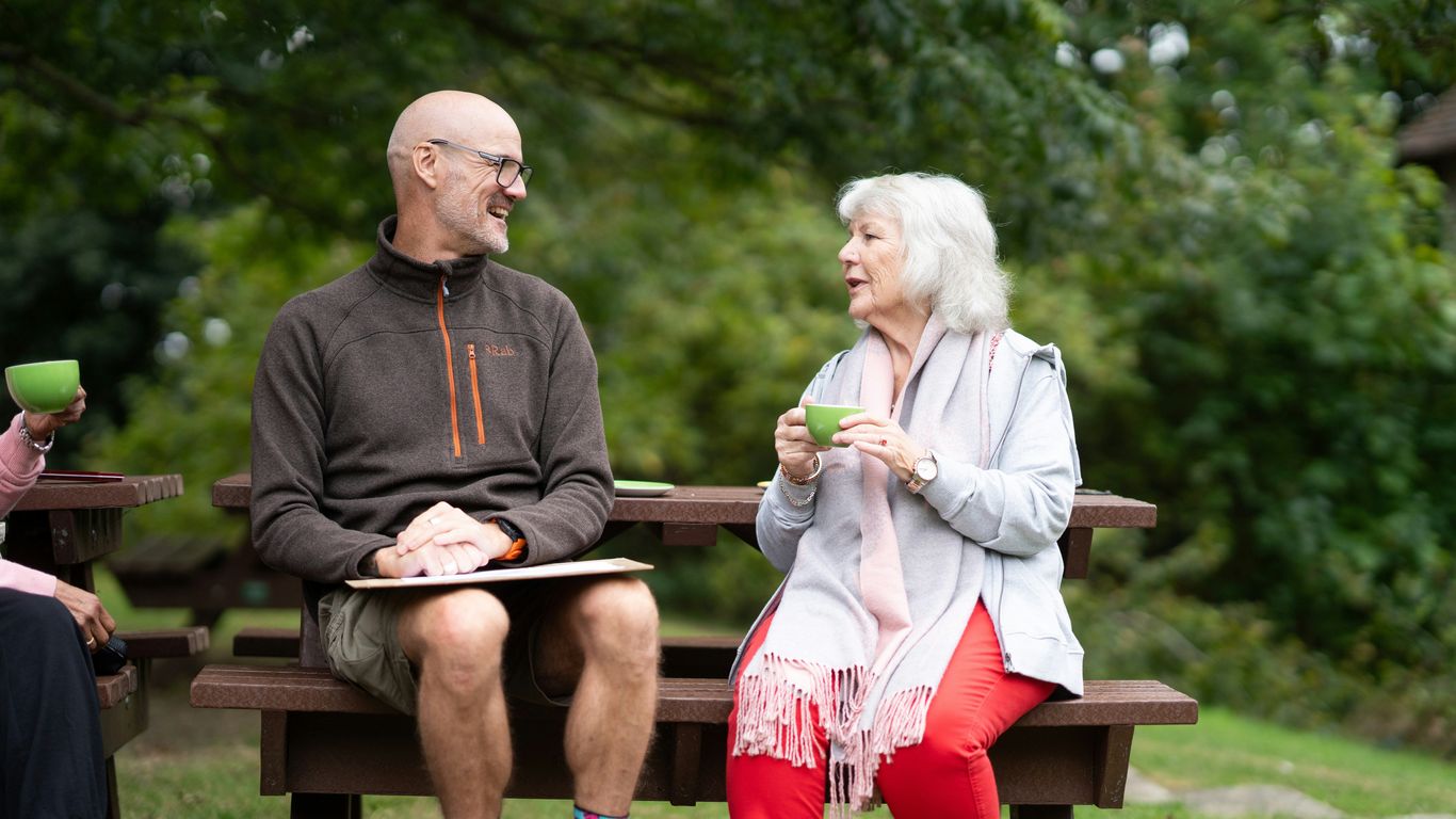 a man and a woman sitting on a park bench