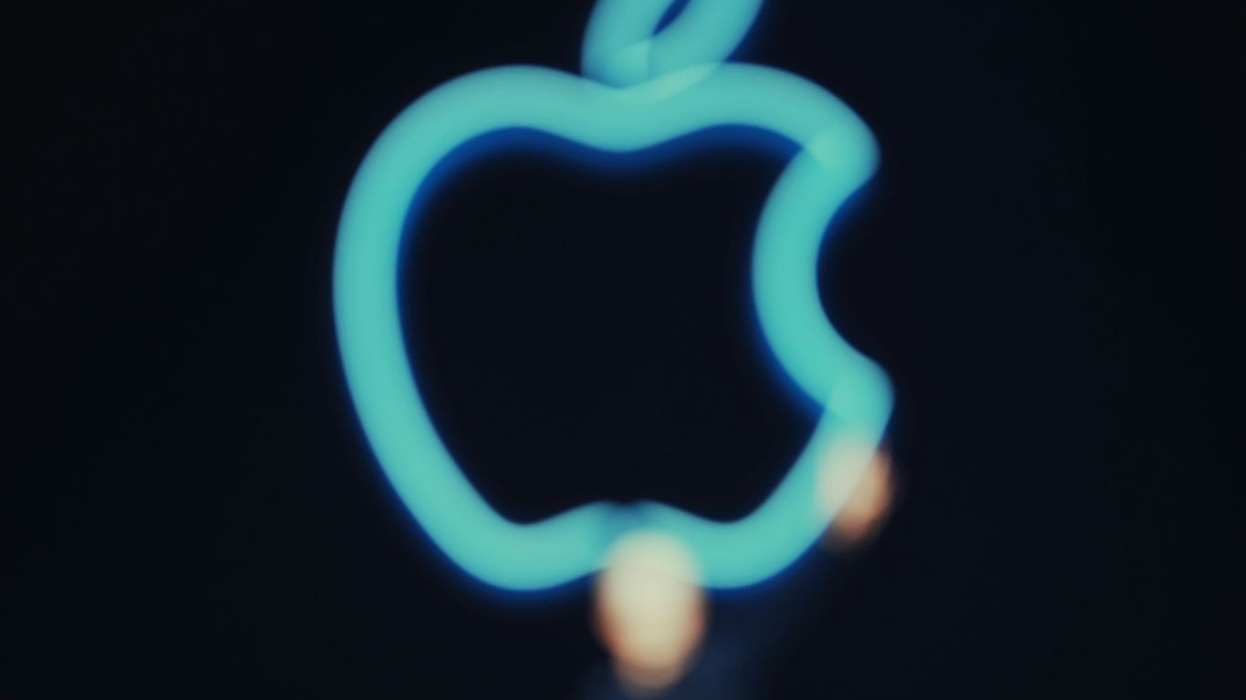 Here's a short caption: a glowing apple logo against a dark background.