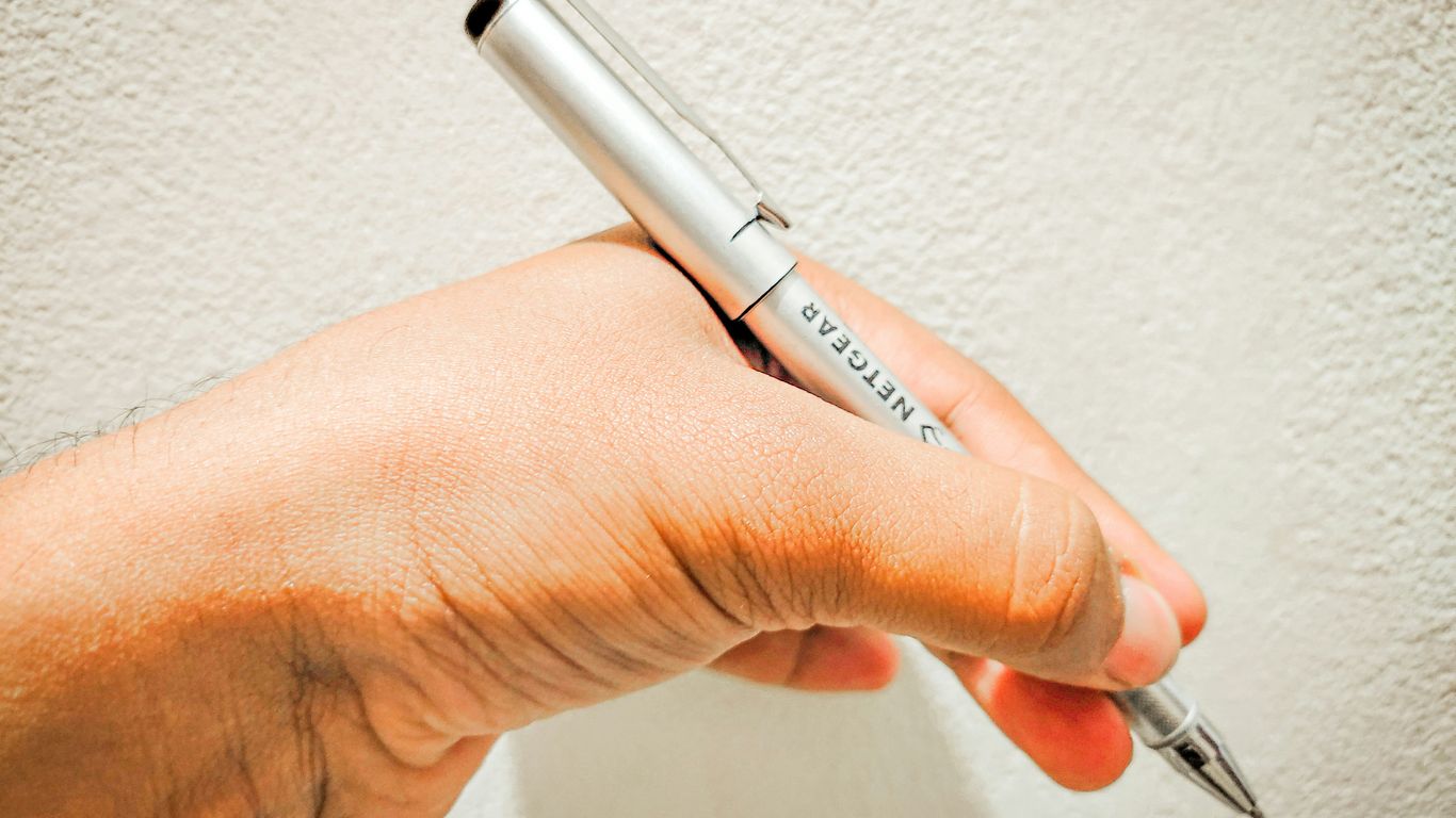 a person holding a pen in their hand