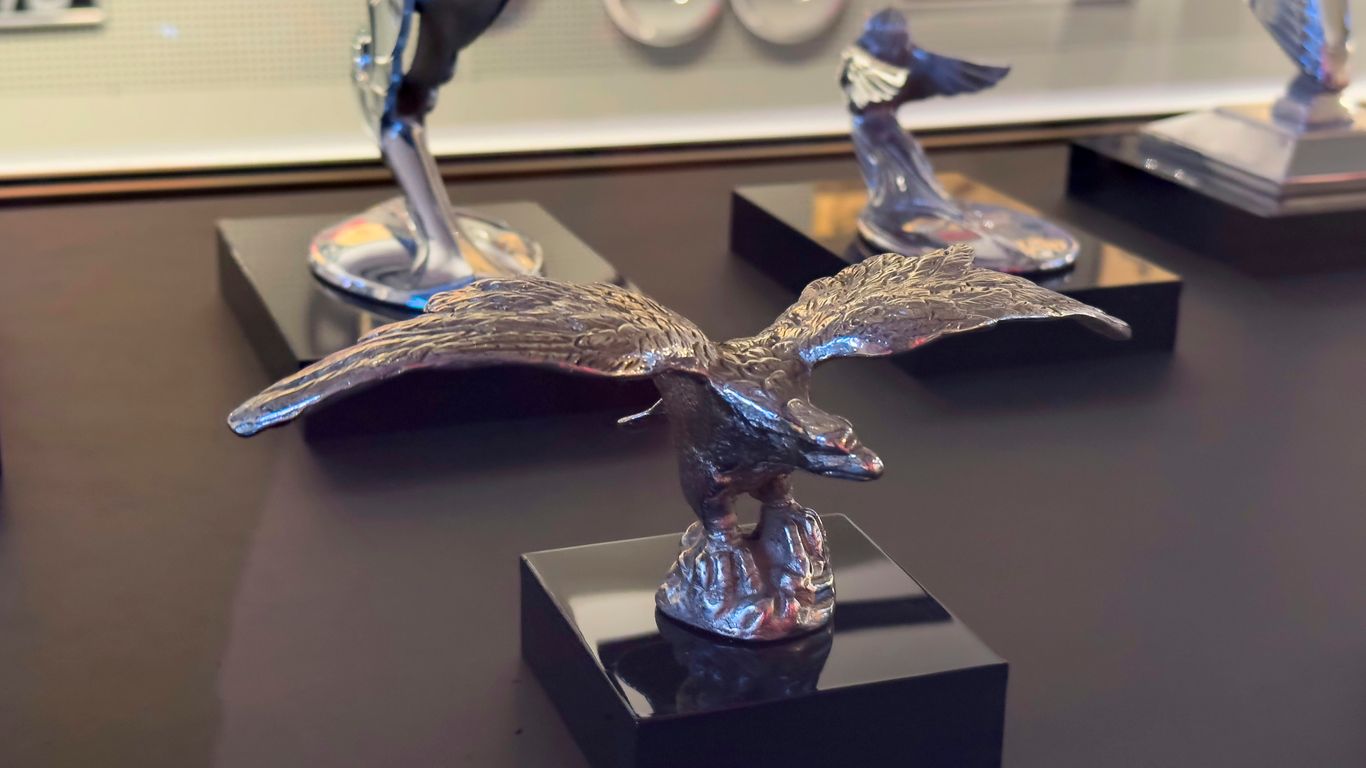 Various antique car hood ornaments are displayed.