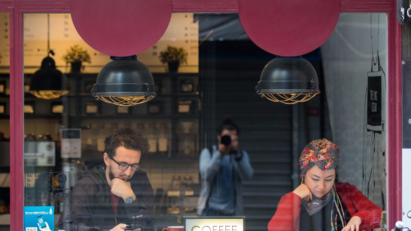 man and woman sitting reading book inside room