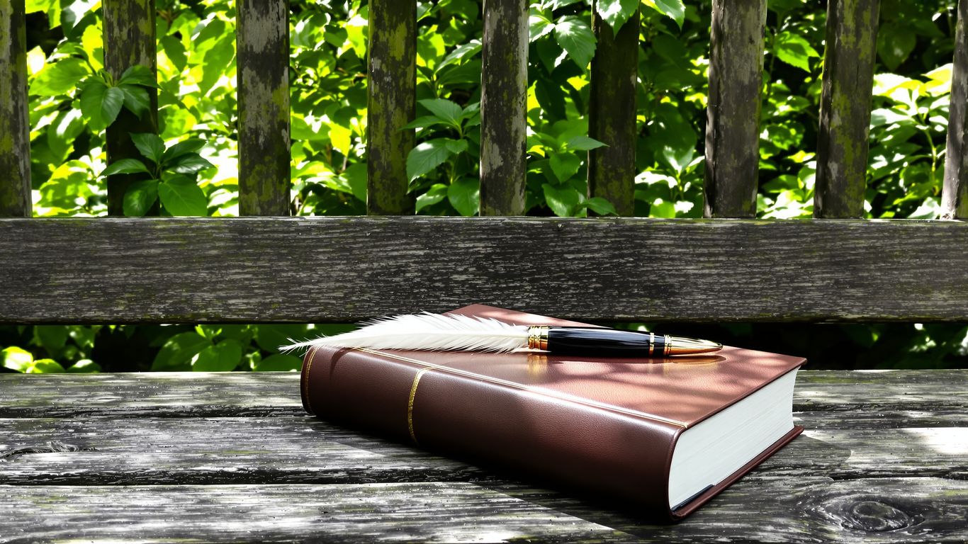 Quill pen on book in peaceful garden.