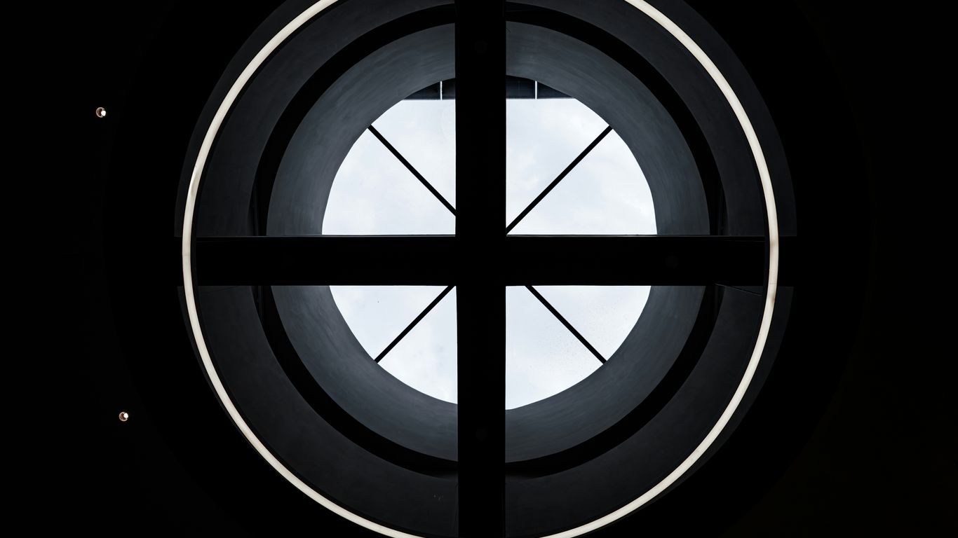 A circular window with geometric black design.