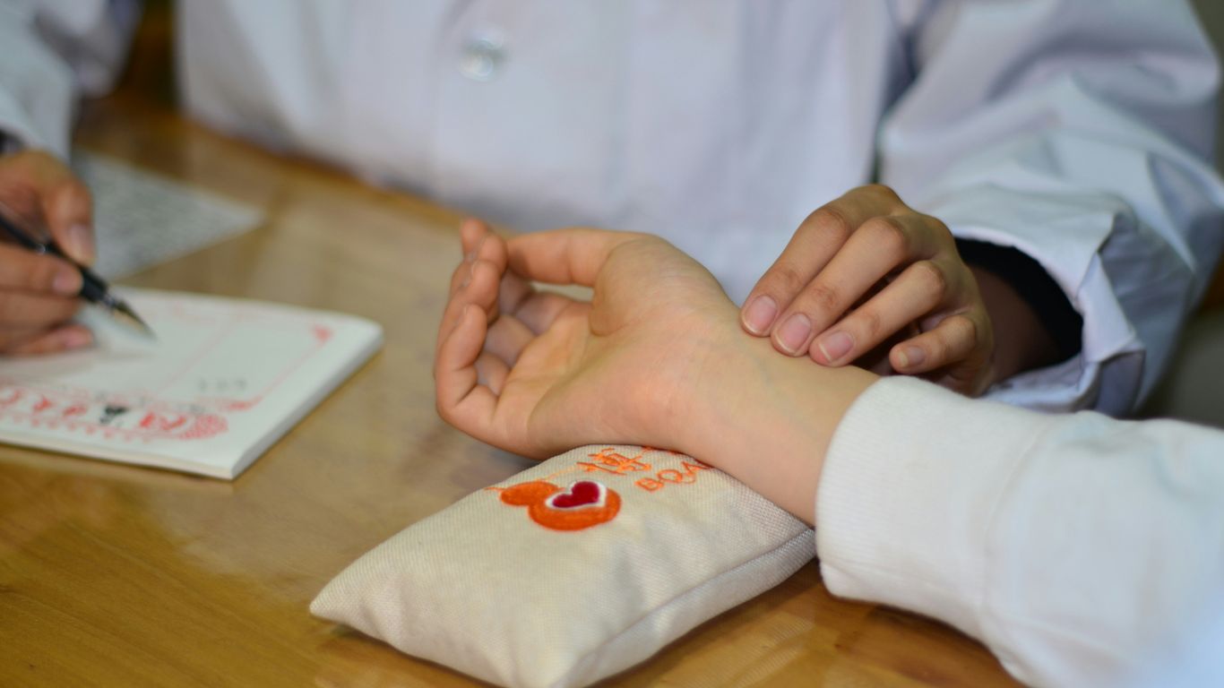 person in white long sleeve shirt with red and white heart tattoo on right hand