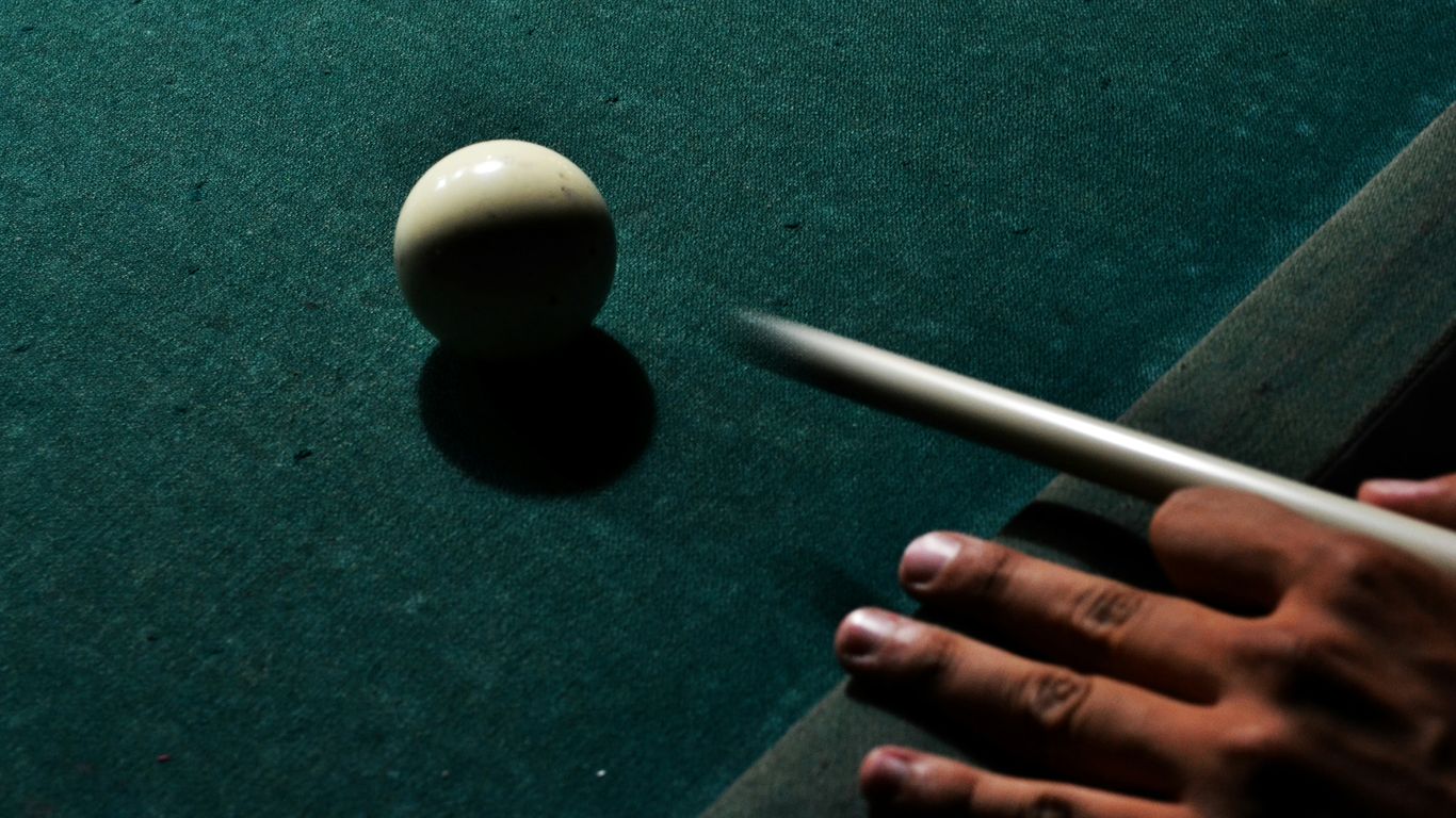 person holding brown cue stick