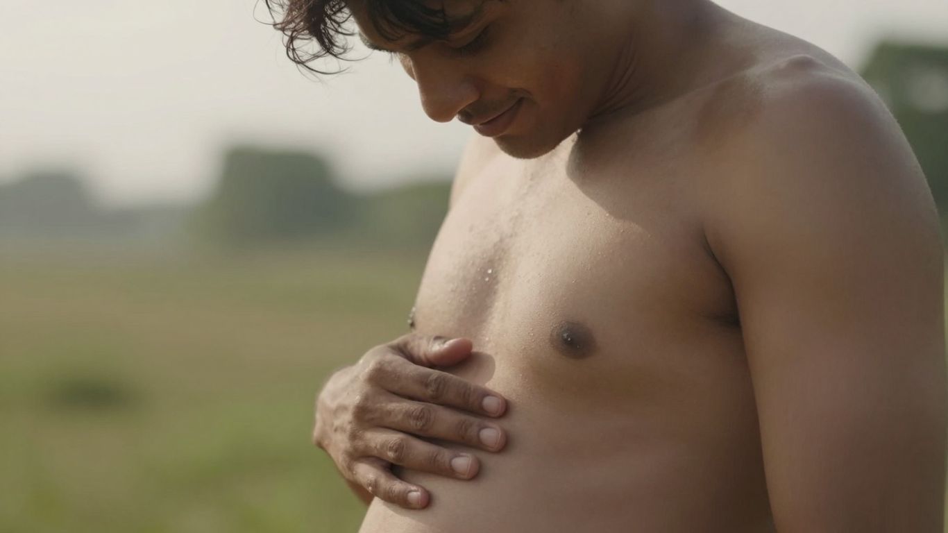 Person touching abdomen with gentle smile, natural light, serene background.