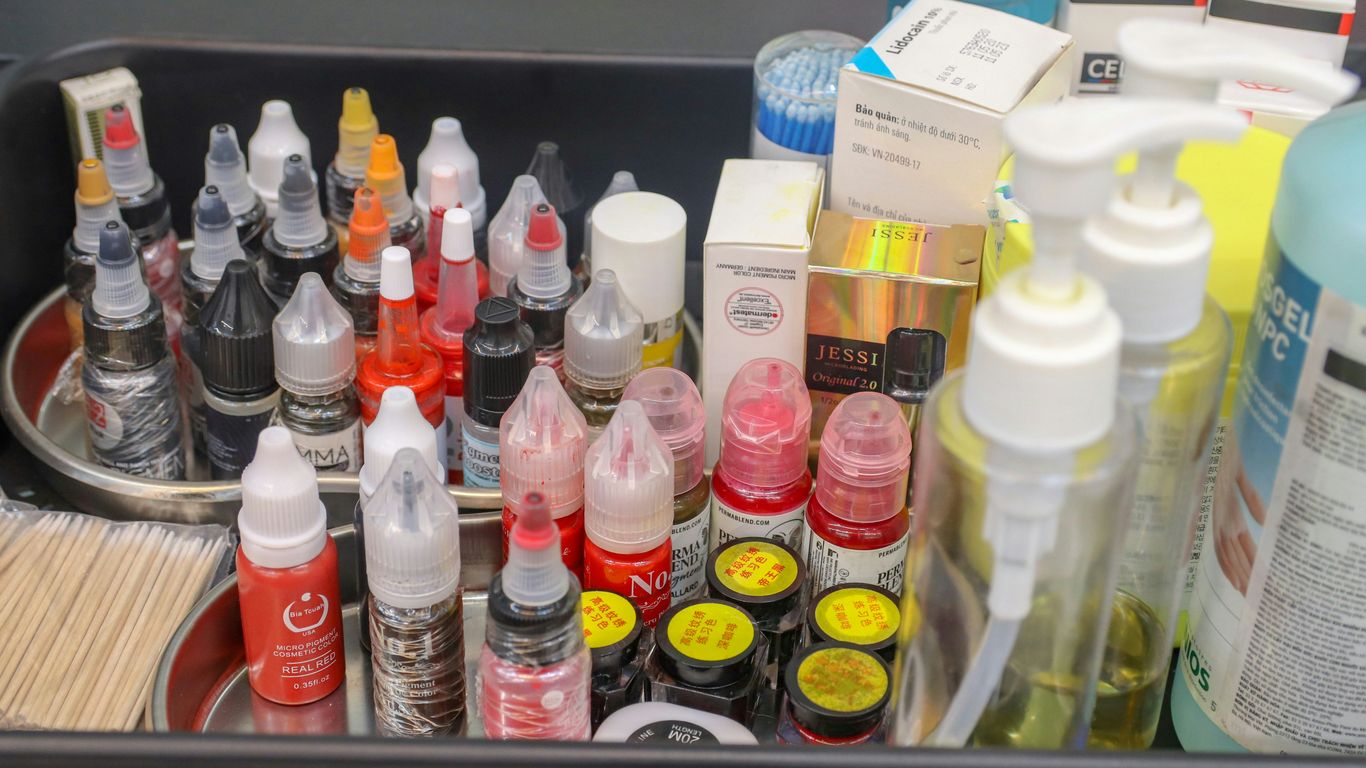 A metal container filled with lots of different types of paint