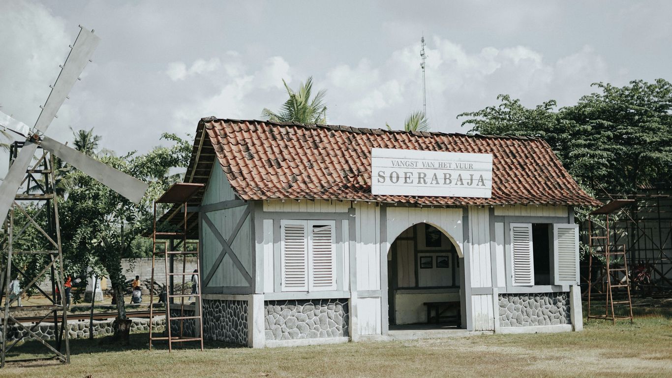 a small building with a windmill in the background