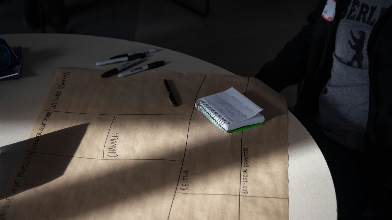 a person sitting at a table with a notebook and pen