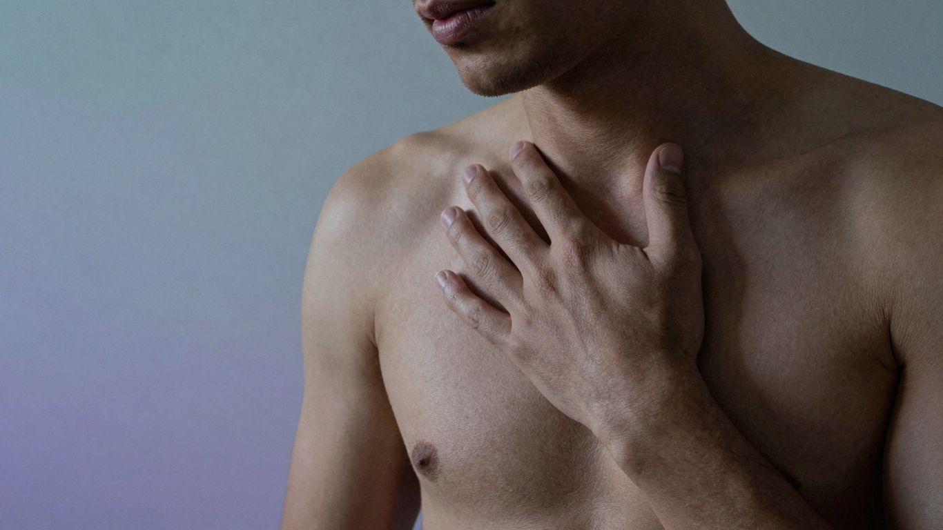 Person experiencing widespread body pain with soft light.