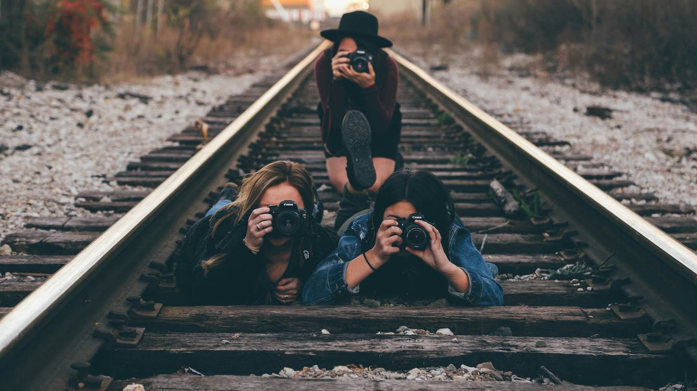 three women in train railway taking picture
