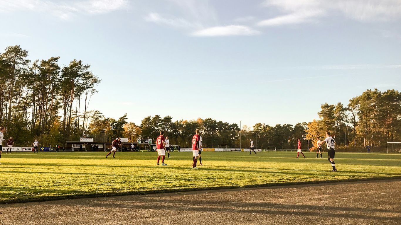 landscape photography of people playing soccer on field during daytime