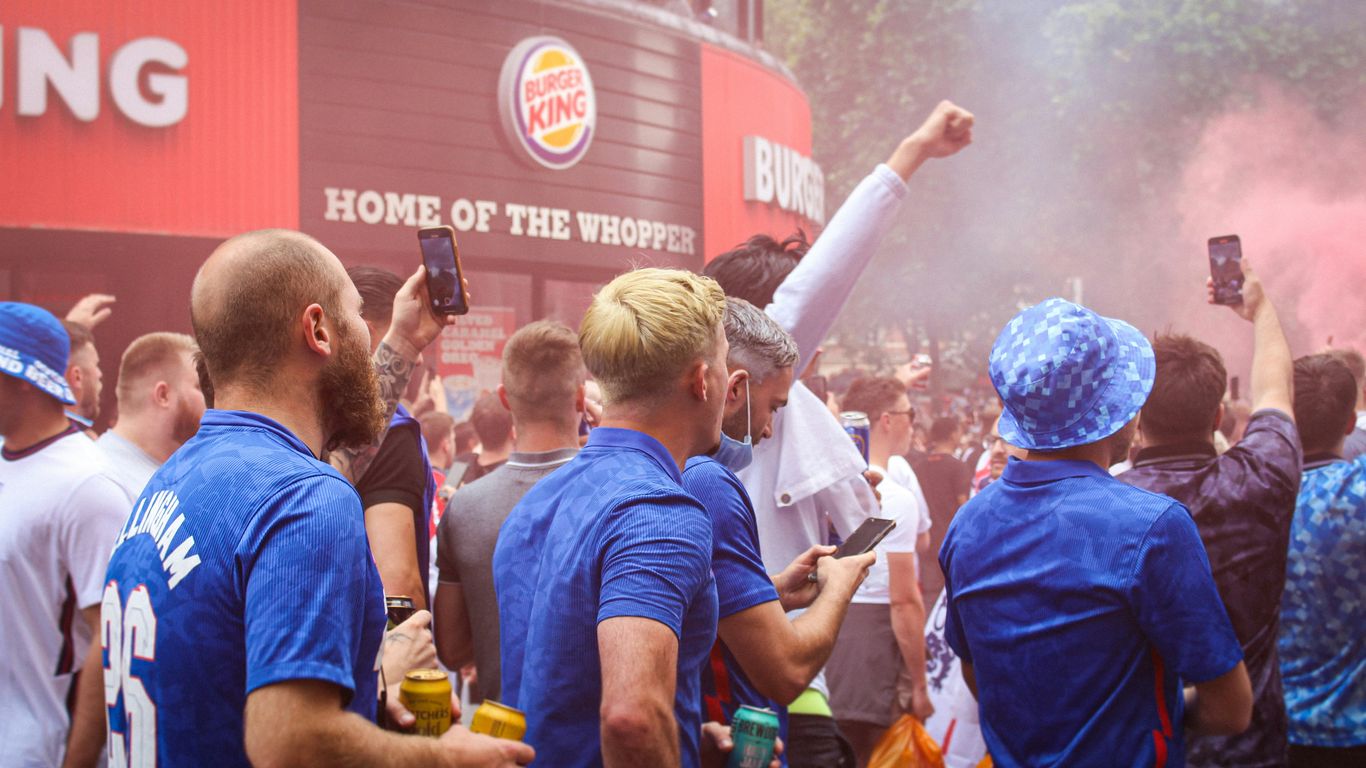people in blue shirts standing and holding yellow and white powder
