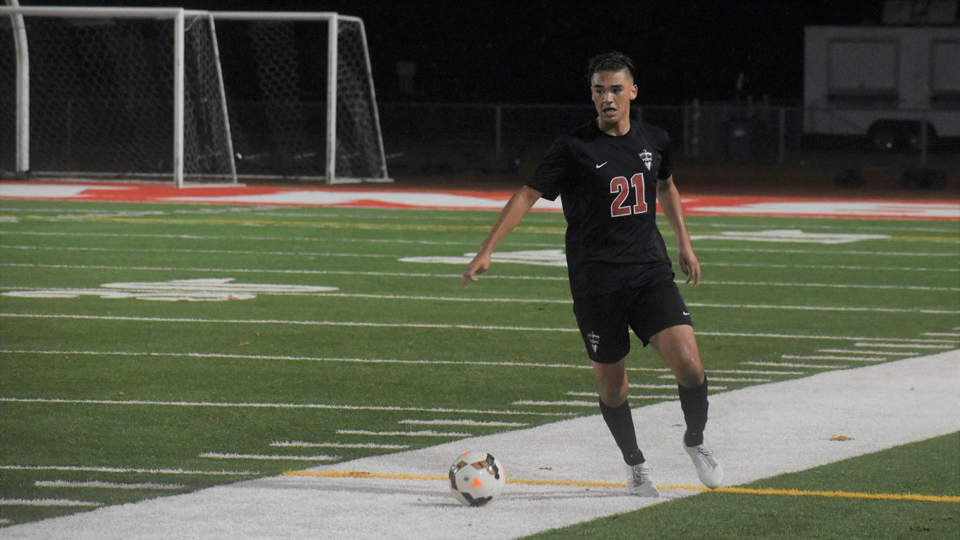 man in black and white soccer jersey kicking soccer ball