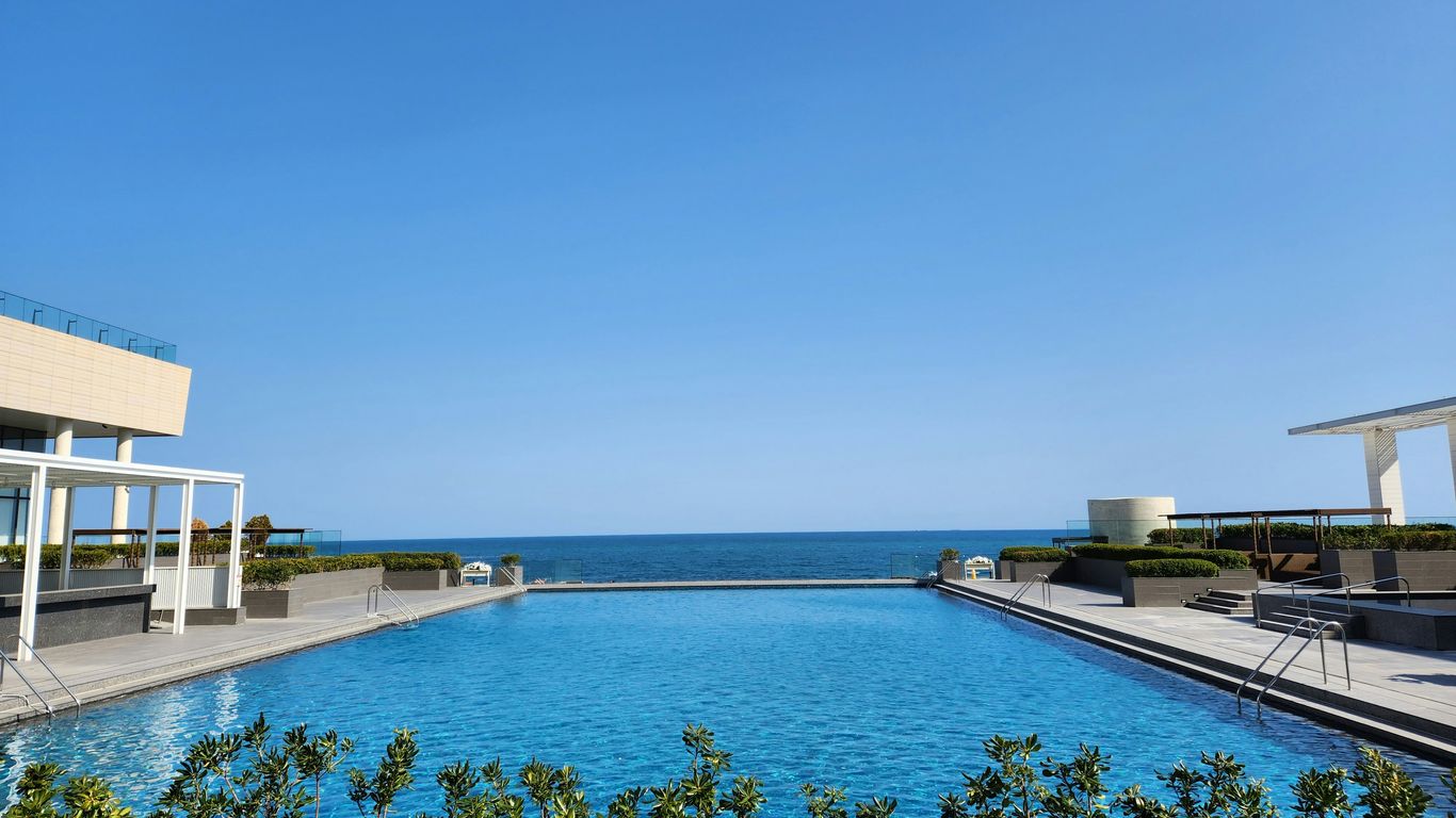 a large swimming pool with a view of the ocean