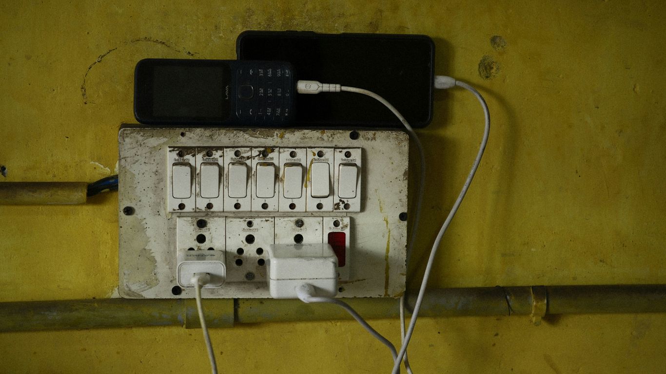 Phones are charging on an electrical outlet.