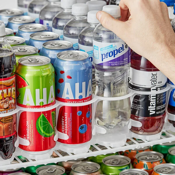 An Avantco gravity-feed bottle organizer filled with various beverage bottles inside a cooler.